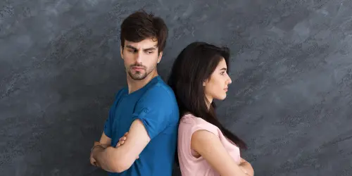 Zwei Menschen Rücken an Rücken – Sinnbild für Konflikte und Kommunikationsschwierigkeiten.“